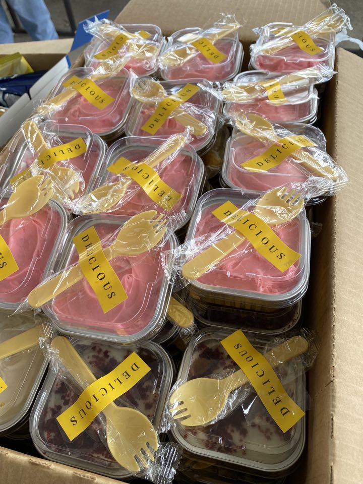 Several containers of dessert with a spork taped on top.